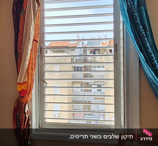 תריסים אופקיים לבנים על חלון עם וילונות צבעוניים